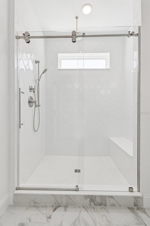 bathroom with a shower stall and a healthy amount of sunlight