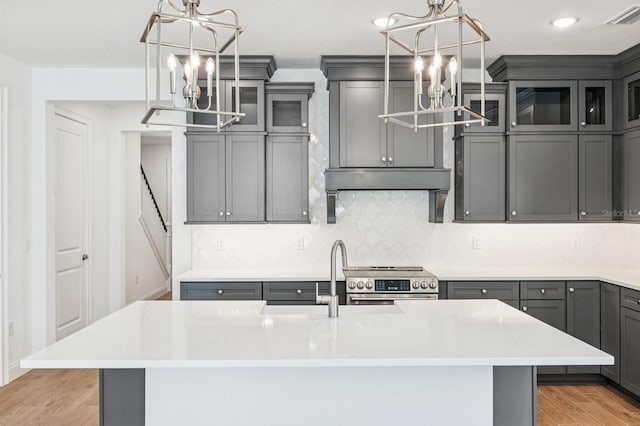 kitchen featuring visible vents, electric range, gray cabinetry, light countertops, and a chandelier