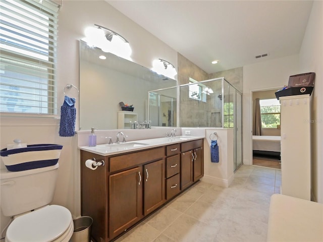 bathroom featuring dual sinks, toilet, tile floors, a shower with door, and large vanity