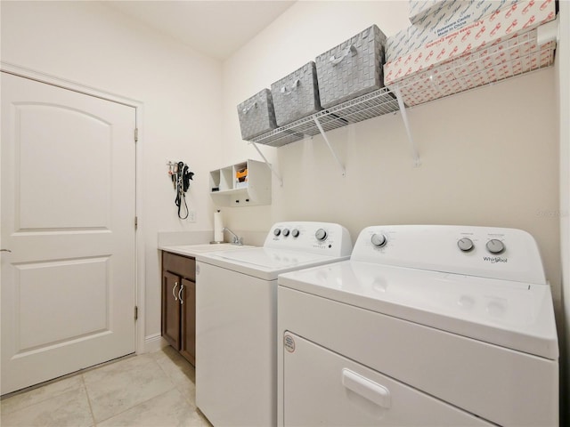 laundry area with washer and dryer, cabinets, sink, and light tile floors