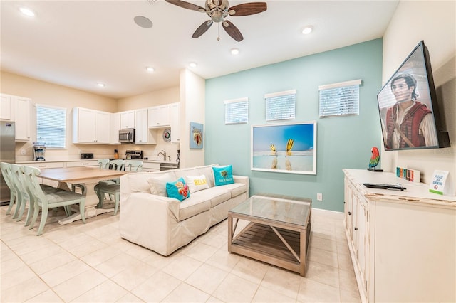 tiled living room featuring ceiling fan and sink