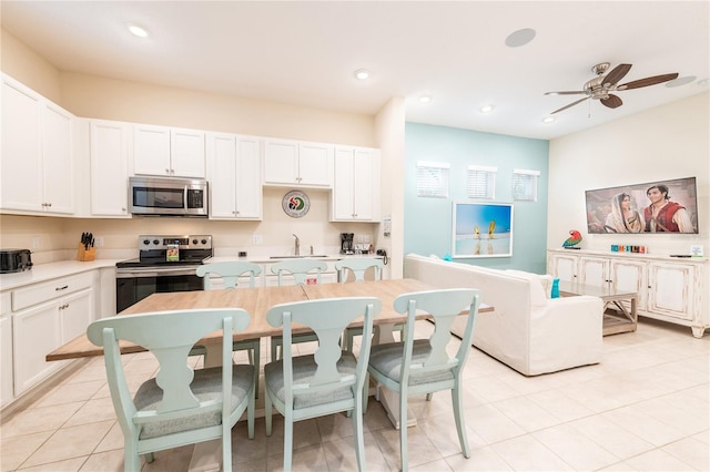 kitchen with white cabinets, ceiling fan, light tile patterned floors, and appliances with stainless steel finishes