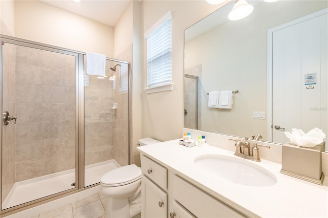 bathroom with tile patterned floors, vanity, toilet, and a shower with shower door