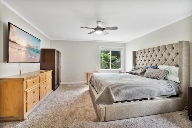 carpeted bedroom with ornamental molding and ceiling fan