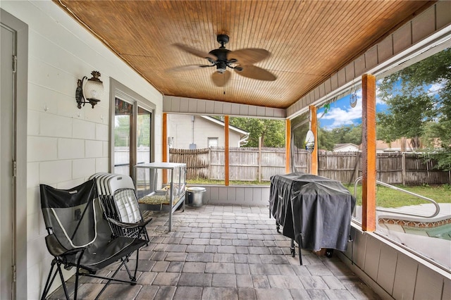 sunroom featuring wood ceiling and ceiling fan