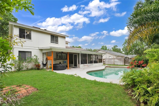 exterior space featuring a sunroom, ceiling fan, a lawn, and a fenced in pool