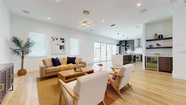 living room with light hardwood / wood-style flooring, beverage cooler, and plenty of natural light