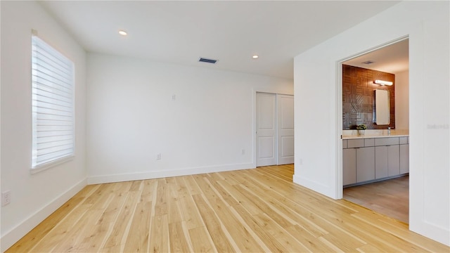 unfurnished room featuring sink and light wood-type flooring