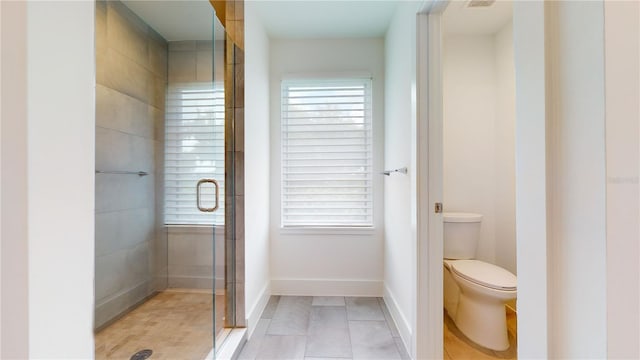 bathroom featuring walk in shower, tile patterned flooring, and toilet