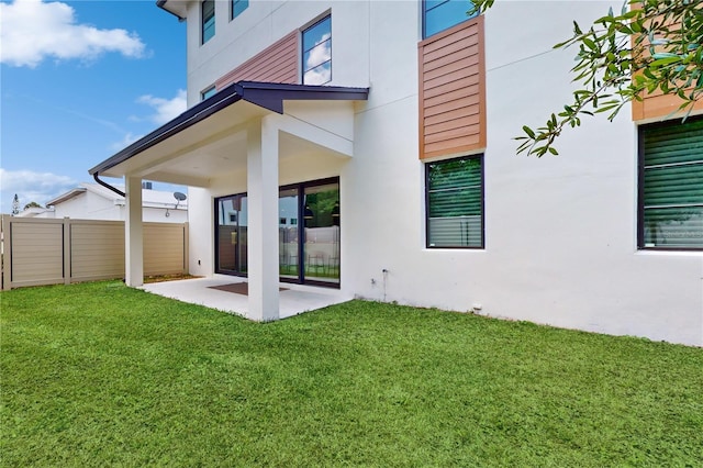 rear view of property with a patio and a lawn