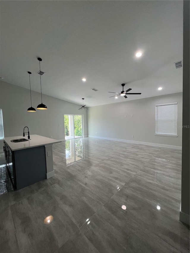 unfurnished living room with ceiling fan, sink, and vaulted ceiling