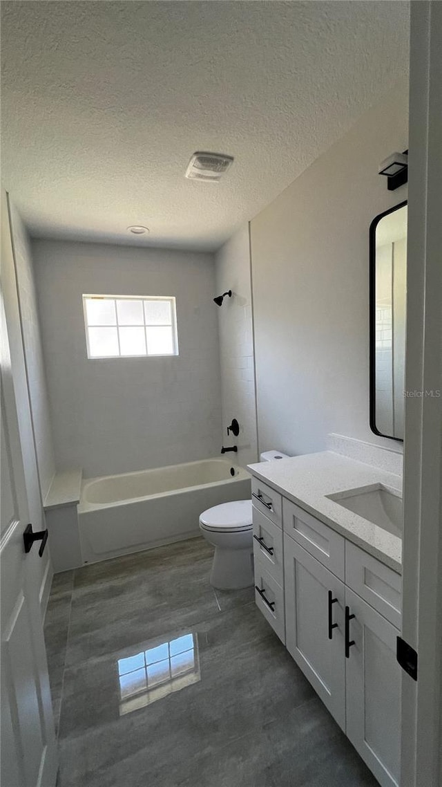 full bathroom with vanity,  shower combination, toilet, and a textured ceiling