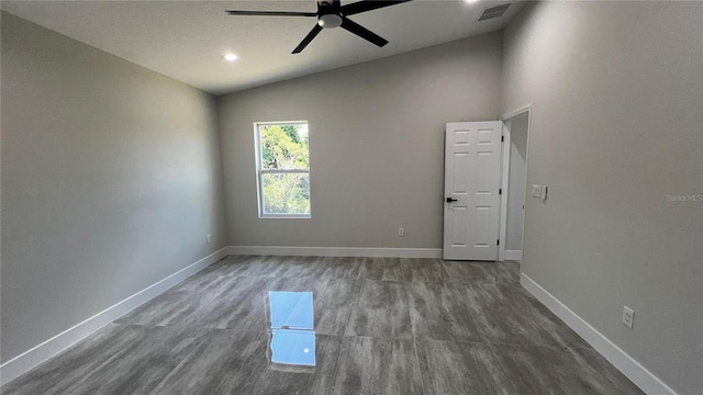 unfurnished room featuring ceiling fan, dark hardwood / wood-style flooring, and lofted ceiling