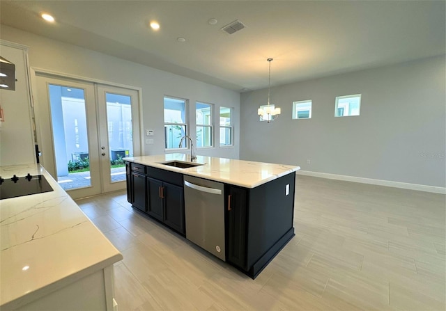 kitchen featuring sink, decorative light fixtures, stainless steel dishwasher, and an island with sink