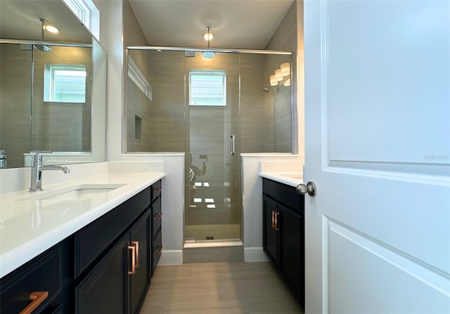 bathroom with vanity, a wealth of natural light, and a shower with door