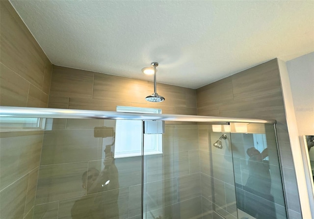 bathroom featuring an enclosed shower and a textured ceiling