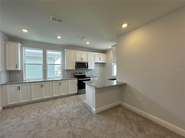 kitchen with stainless steel appliances, light stone countertops, and white cabinets