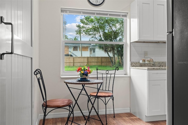 dining area featuring light wood-style flooring, baseboards, and a wealth of natural light