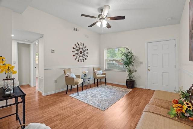 sitting room featuring ceiling fan, wood finished floors, visible vents, and baseboards