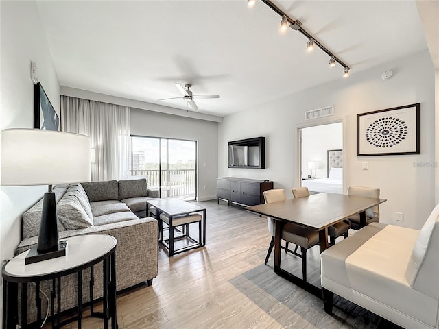 living room featuring light wood-type flooring, track lighting, and ceiling fan