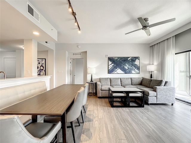 dining space featuring ceiling fan, light hardwood / wood-style floors, and rail lighting