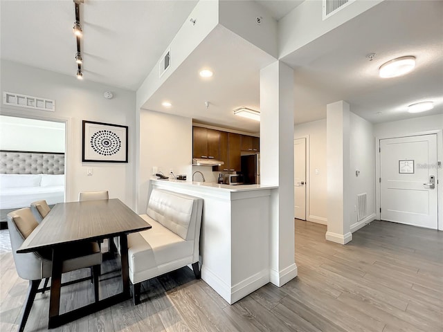 dining room featuring track lighting and light hardwood / wood-style flooring