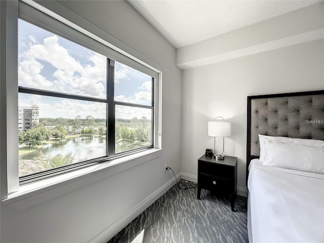 carpeted bedroom with a water view