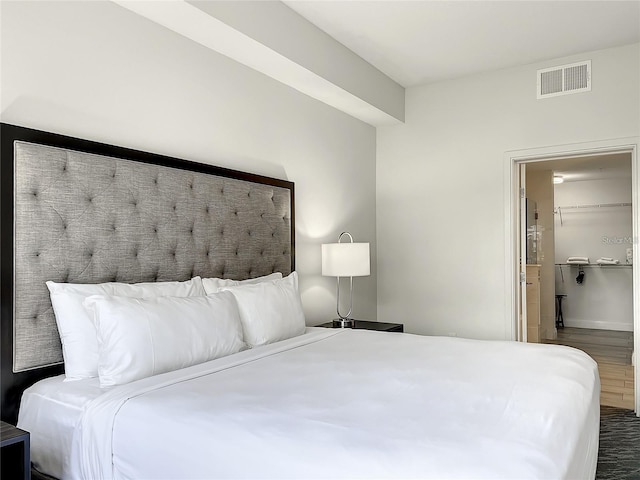 bedroom featuring dark hardwood / wood-style flooring and a walk in closet