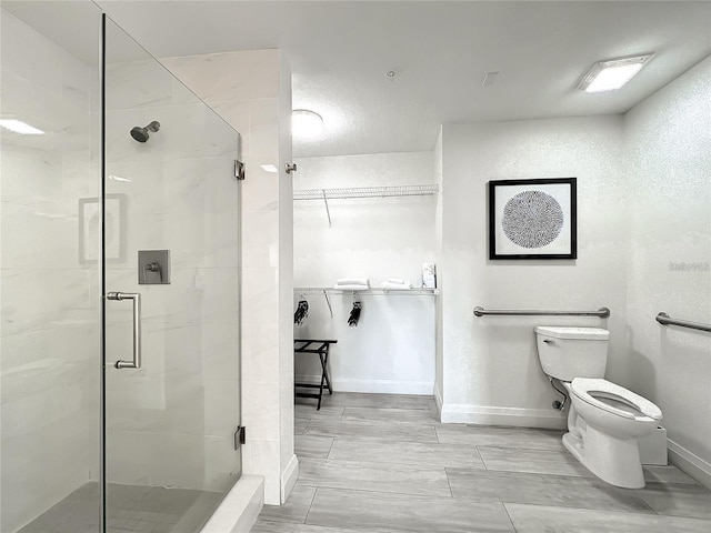 bathroom with tile floors, a shower with shower door, and toilet