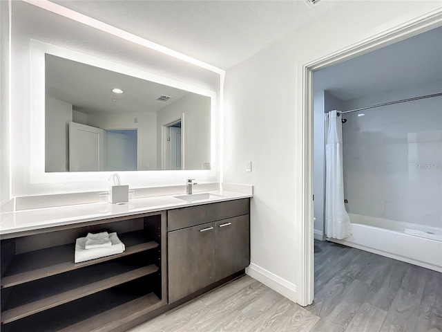 bathroom featuring double vanity, hardwood / wood-style floors, and shower / bath combo with shower curtain