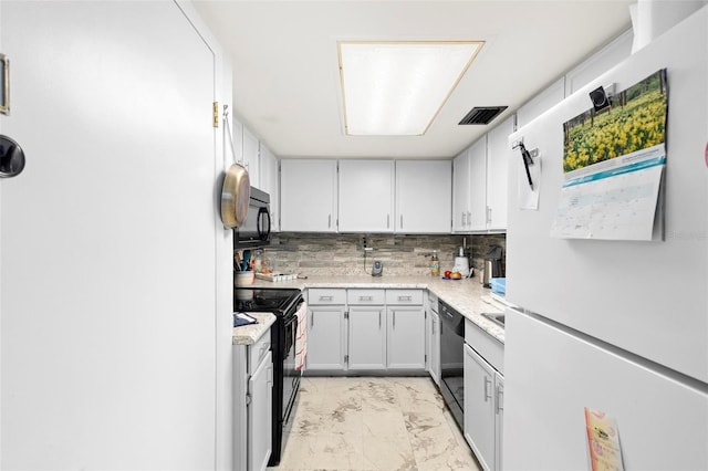 kitchen featuring backsplash, black appliances, light tile floors, and gray cabinets