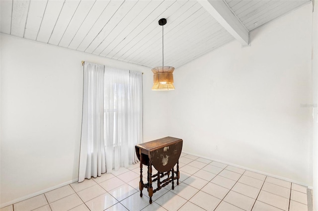 dining room with lofted ceiling with beams and light tile flooring