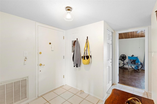 foyer with a textured ceiling and light tile floors