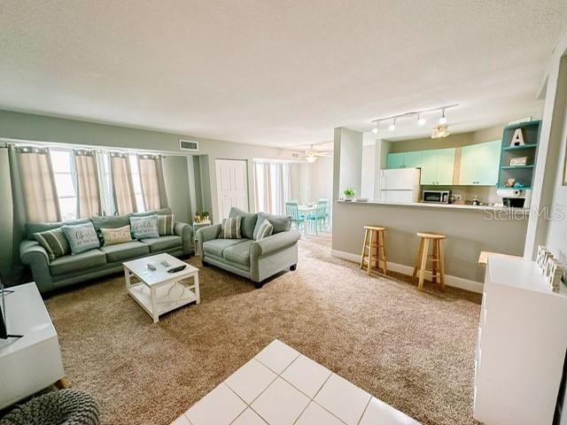 living room with light carpet and ceiling fan