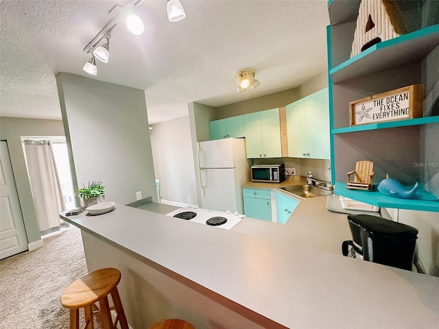 kitchen with kitchen peninsula, sink, light colored carpet, and white refrigerator