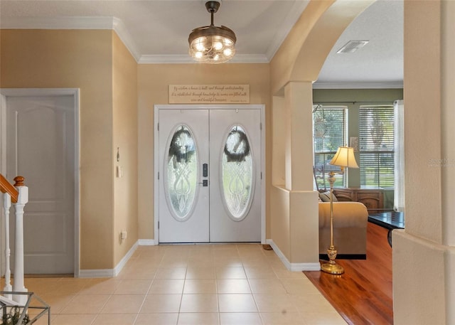 tiled foyer entrance featuring ornamental molding and french doors