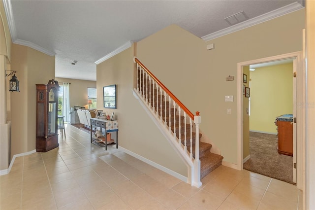 stairs with a textured ceiling, tile patterned floors, and crown molding