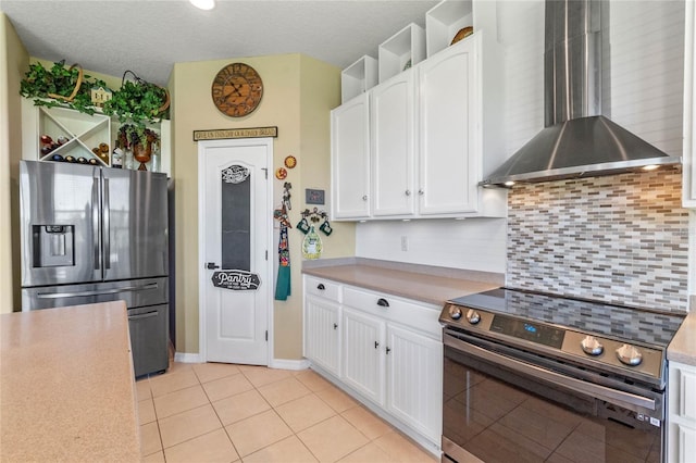 kitchen featuring white cabinets, appliances with stainless steel finishes, and wall chimney exhaust hood