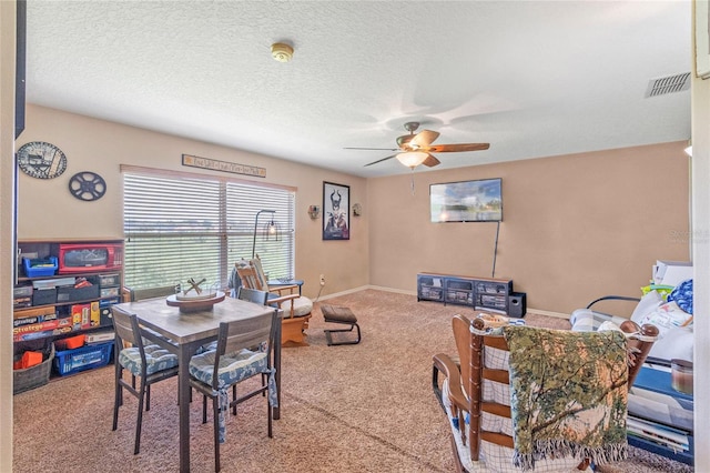 dining space with ceiling fan, a textured ceiling, and carpet flooring