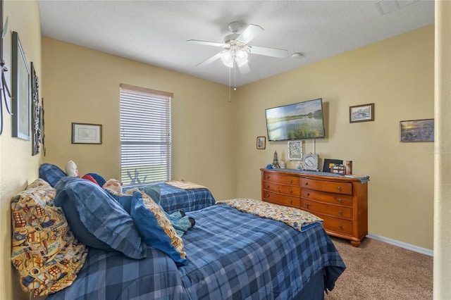 carpeted bedroom featuring a textured ceiling and ceiling fan