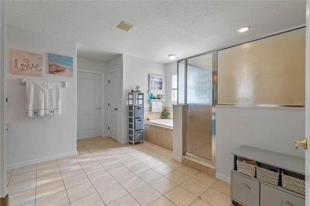 bathroom with a textured ceiling, tile patterned flooring, and shower with separate bathtub