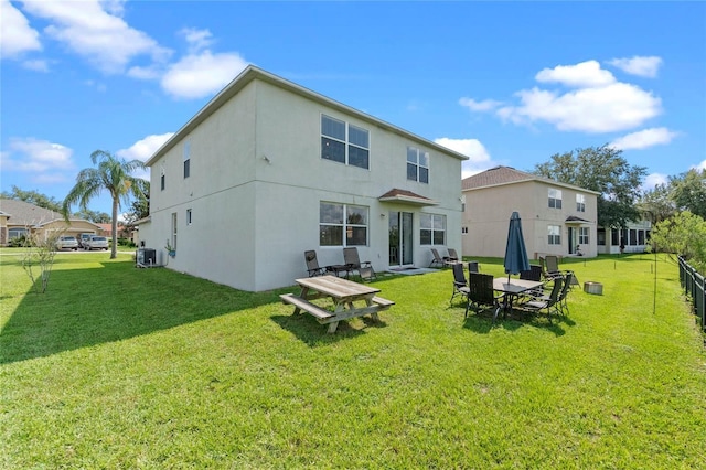 rear view of property with a lawn and central AC