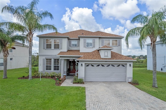 mediterranean / spanish house featuring a garage and a front lawn