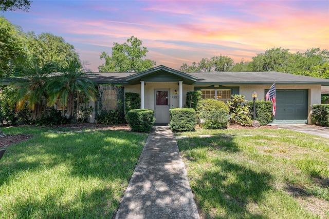 single story home featuring a yard and a garage