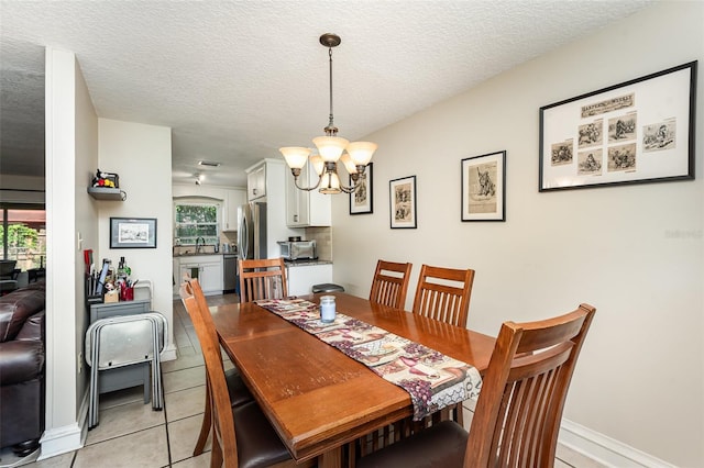 tiled dining room featuring a chandelier, a textured ceiling, and sink