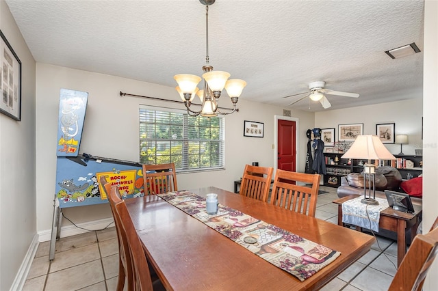 tiled dining area featuring a textured ceiling and ceiling fan with notable chandelier