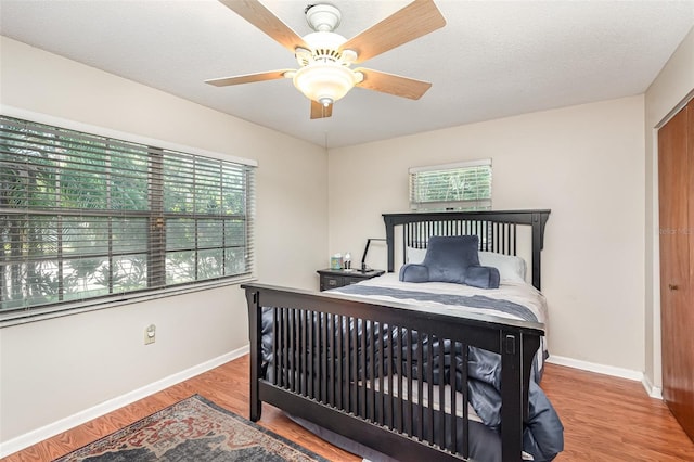 bedroom featuring ceiling fan, a textured ceiling, and hardwood / wood-style flooring