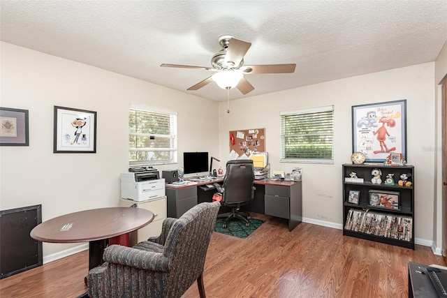 office featuring hardwood / wood-style floors, ceiling fan, a healthy amount of sunlight, and a textured ceiling