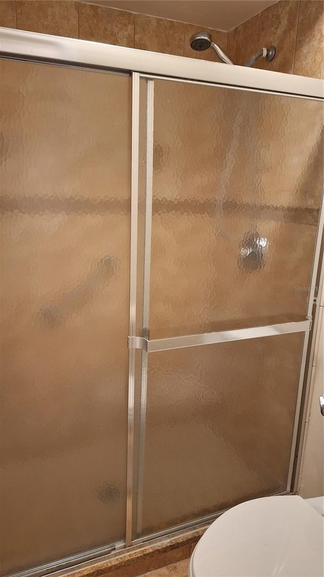 bathroom featuring a stall shower and toilet