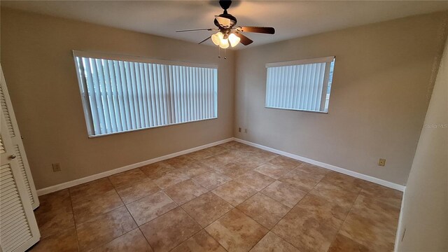 tiled spare room featuring ceiling fan